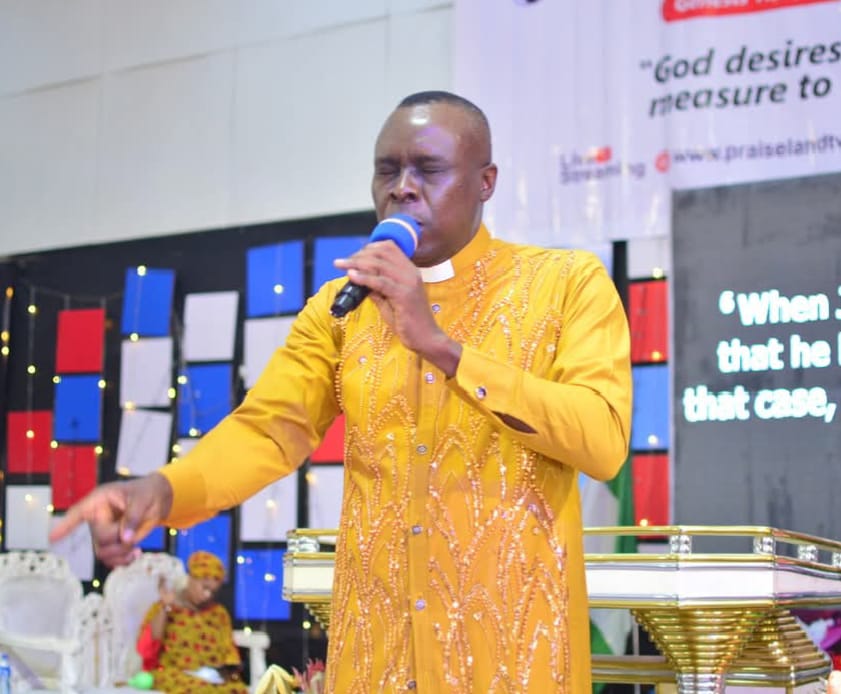 Apostle Prof. E. C. Ejiofor ministering with microphone at Praiseland Royal Springs Int'l Church